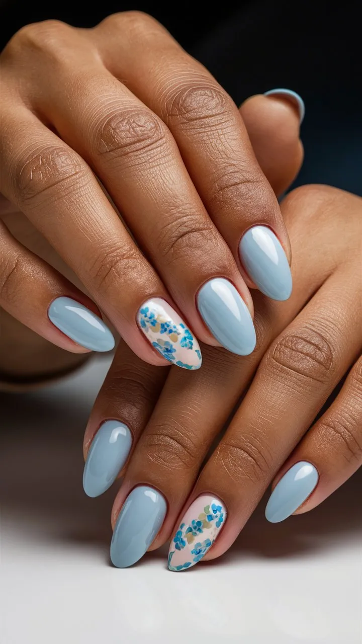 Close-up of nails painted with baby blue nail polish, creating a soft and stylish appearance.