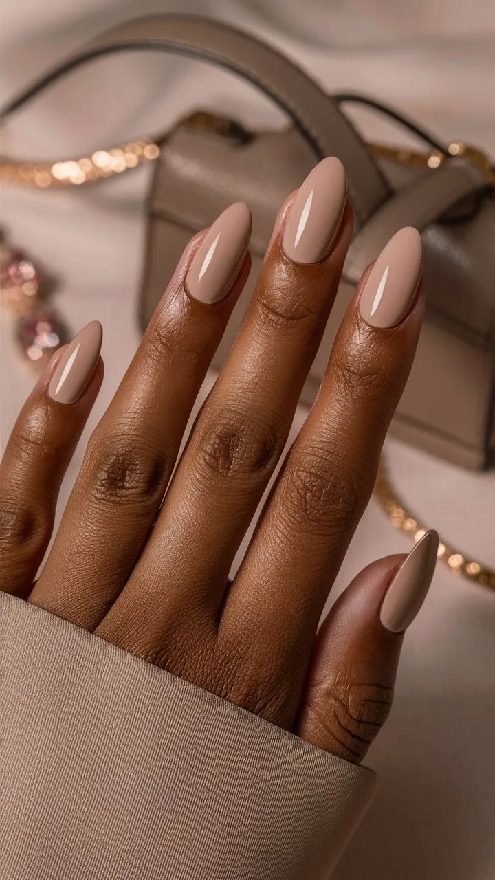 The close-up shows a hand with square-shaped nails painted in taupe—a blend of gray and brown for a subtle, stylish look. The matte finish adds softness. The hand is elegantly posed against a matching background, highlighting its polished appearance. This image captures taupe's simple beauty and versatility, perfect for any occasion.