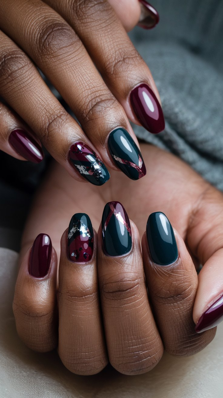 Close-up of manicured nails in deep winter shades like burgundy, midnight blue, and charcoal gray with intricate patterns and glossy finish.