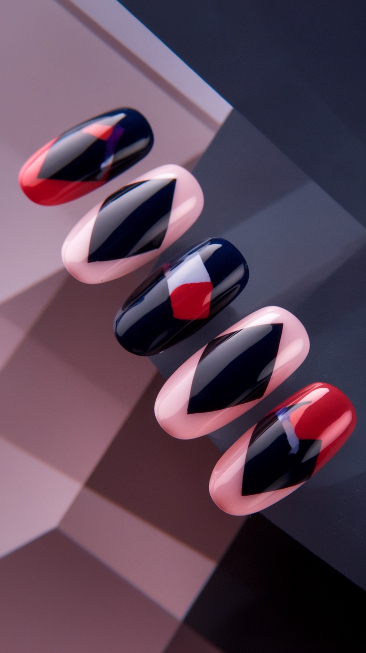 Close-up of nails with geometric designs in red, pink, and navy colors