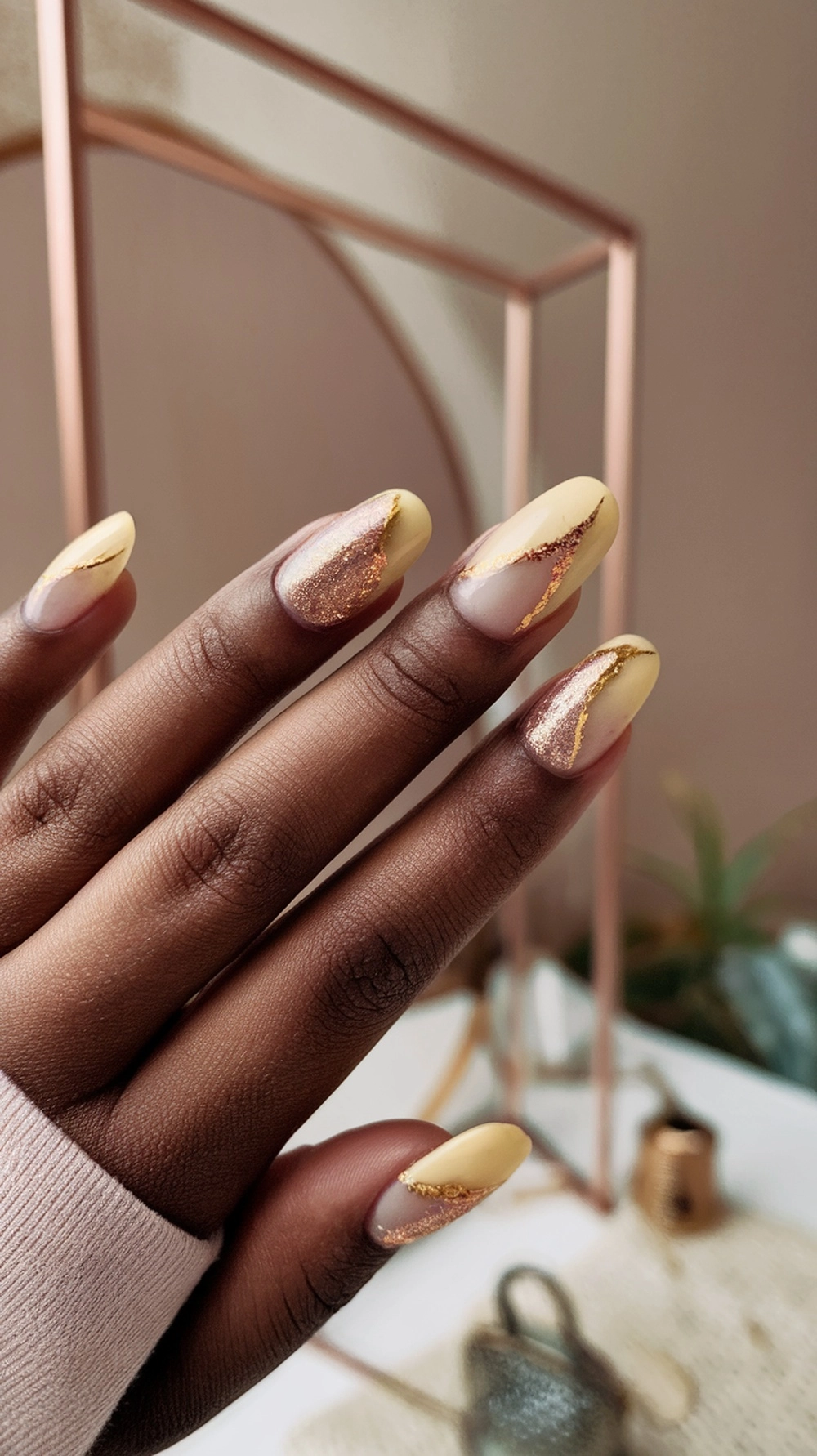 Image of beautifully designed butter yellow nails with glitter and gold accents.
