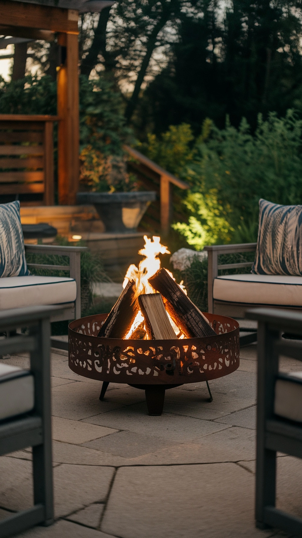 A cozy metal fire ring with burning logs surrounded by outdoor seating.