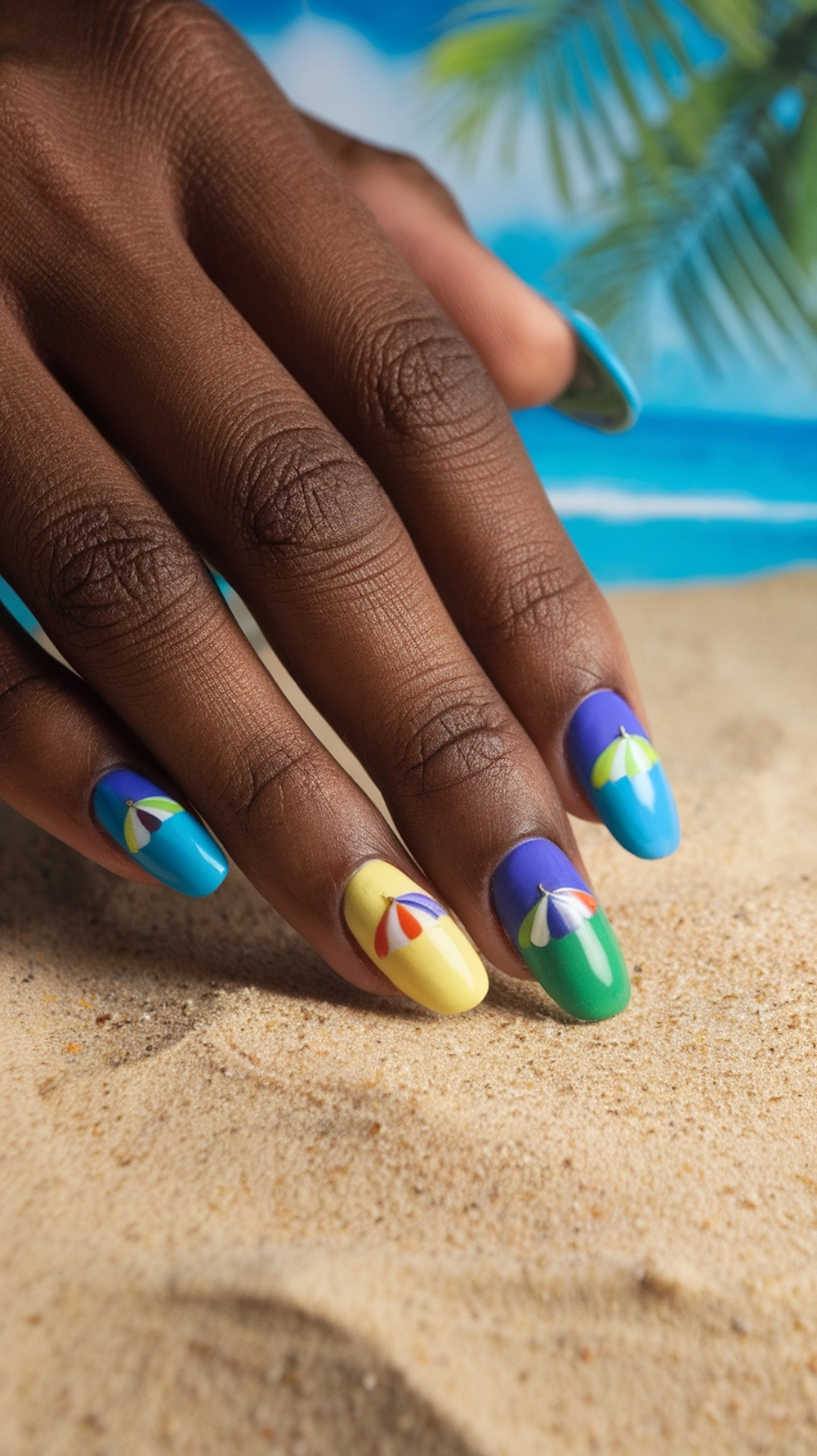 Colorful beach umbrella nail art on a hand with a sandy background