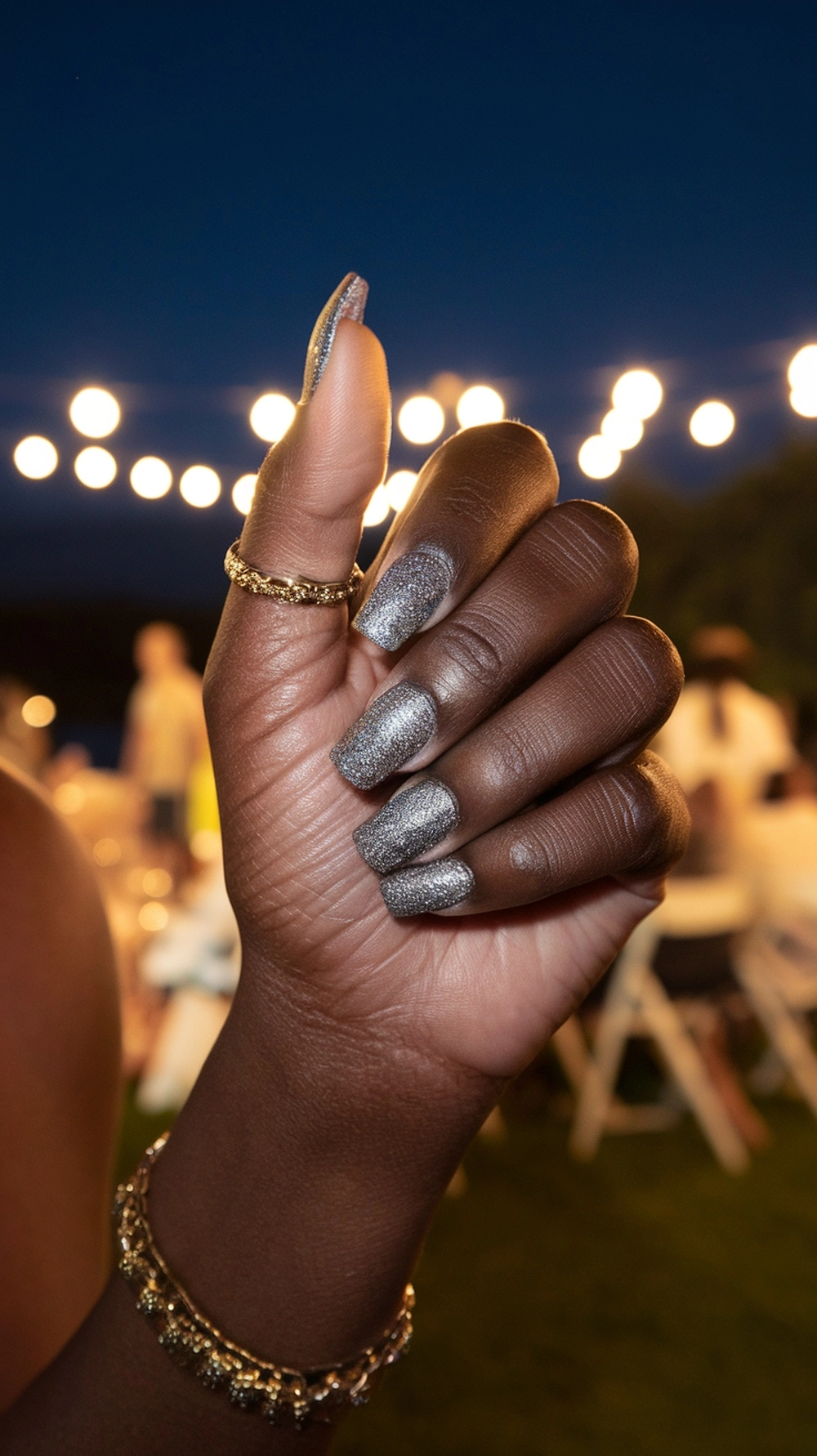 Close-up of hands with glittery summer nails featuring palm tree and heart designs.