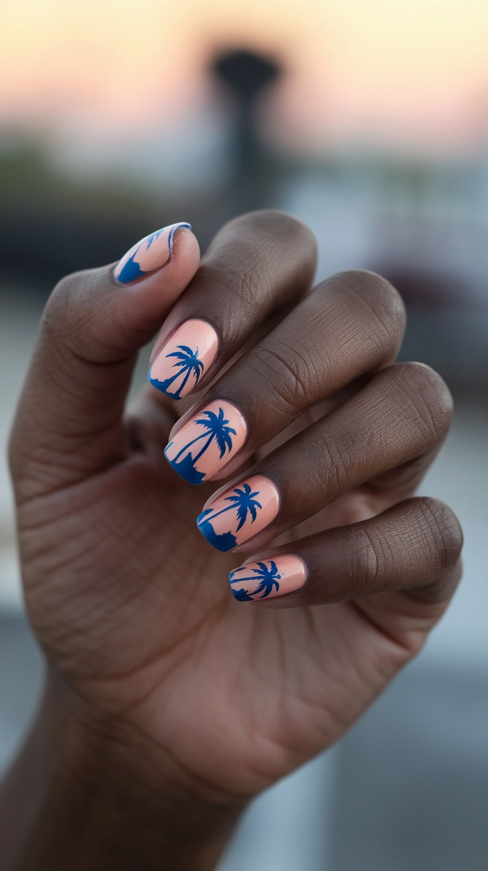 Nail art featuring palm tree silhouettes against a pastel background.