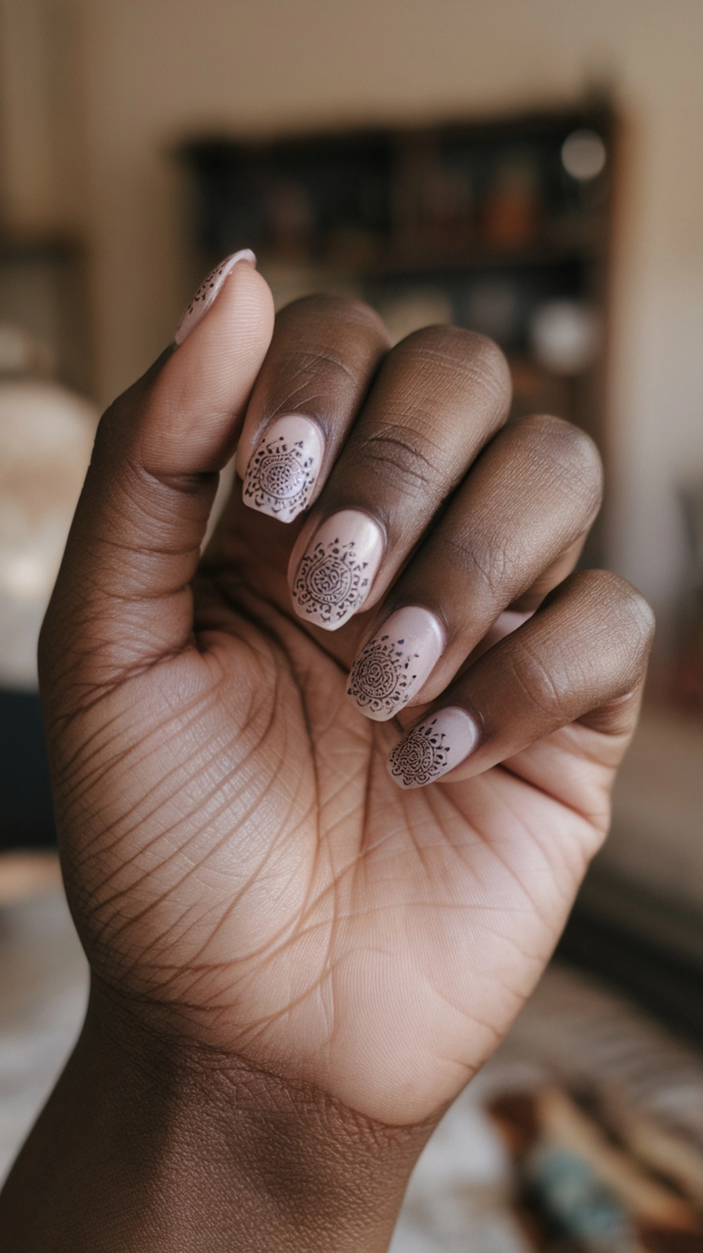 16 Cute Boho Nail Ideas You’ll Love 4 Close-up of hands with mandala patterned nails on a neutral base.