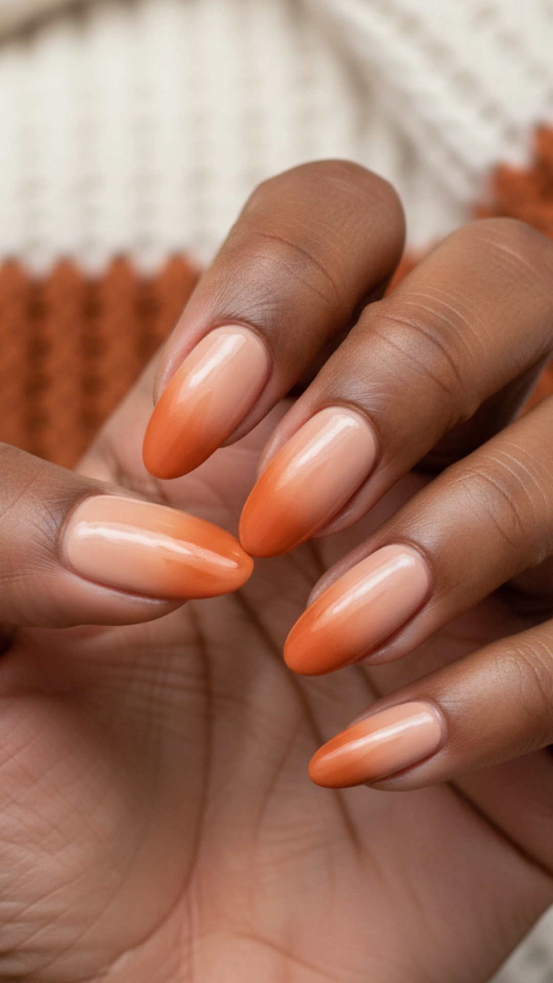 25 Jaw-Dropping Fall Nail Ideas You Must Try 2 Almond-shaped nails showcasing a pumpkin spice ombre design, fading from nude to burnt orange.
