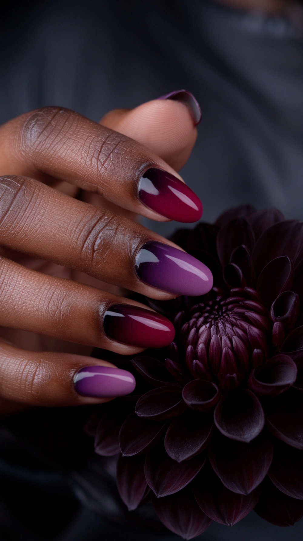 How to Create the Perfect Fall Ombre Nails at Home 6 Hand holding a dahlia, showing plum and wine-red ombre nails.