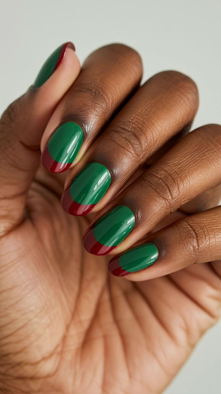 A clean manicure featuring bright holly green polish and a crimson red half-moon design at the nail base.
