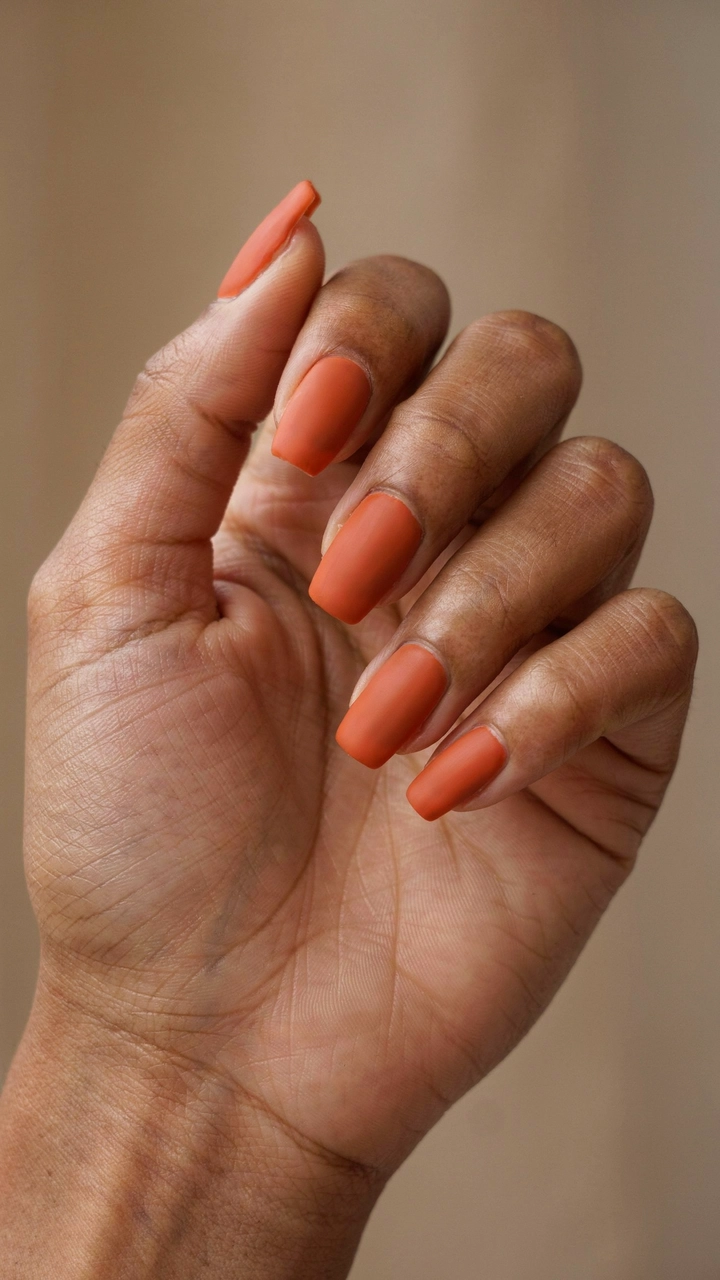 21 Cozy Fall Nail Ideas for a Warm Seasonal Look 6 Beautiful hand with matte burnt orange manicured nails.
