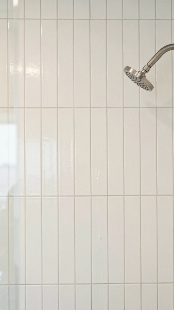 21 Cozy Bathroom Ideas for Small Spaces That Feel Surprisingly Spacious 15 White rectangular subway tiles stacked vertically on a shower wall with light grey grout lines.