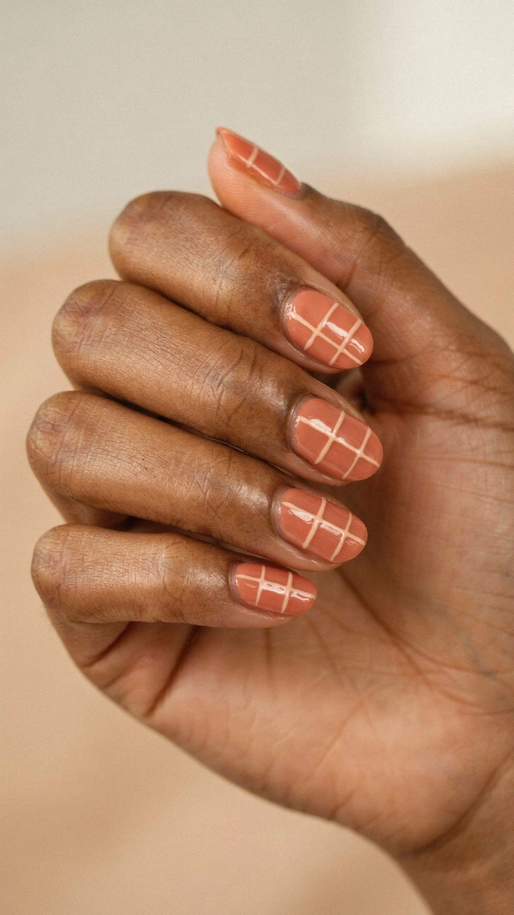 21 Cozy Fall Nail Ideas for a Warm Seasonal Look 11 Terracotta color nails with nude grid lines.