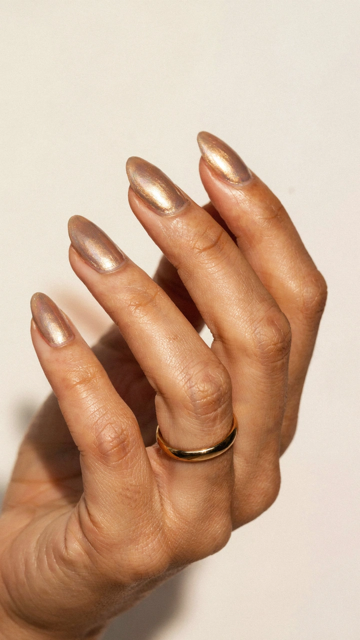Champagne chrome nails for September on a woman's hand 